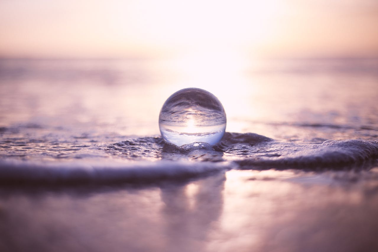 A glass globe on the beach - Photo by Josh Sorenson